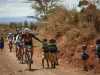 Deelnemers Africa Classic deelt vanaf de fiets high fives uit aan juichende kinderen